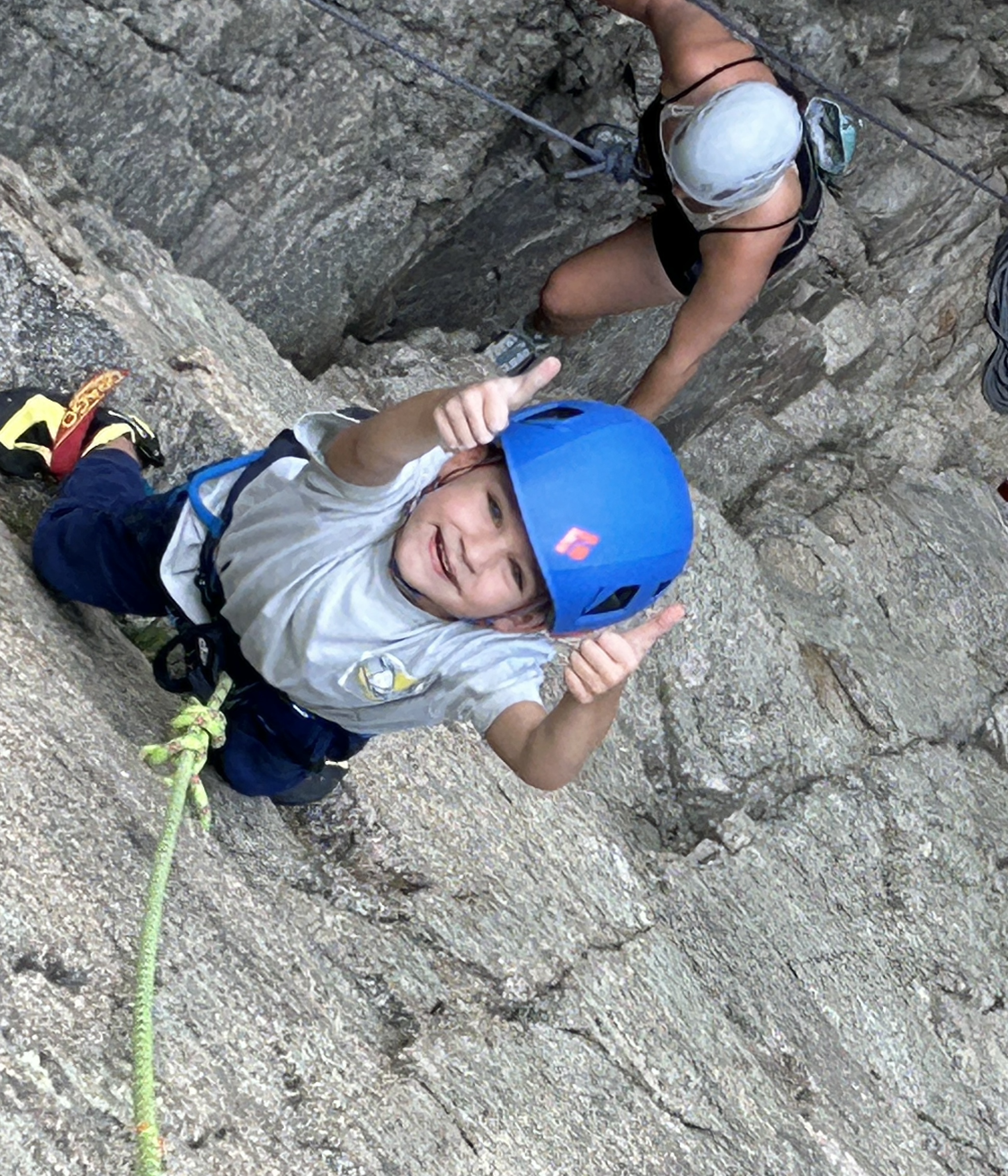 A young boy giving both thumbs up while on a Climbing With Clay expedition.